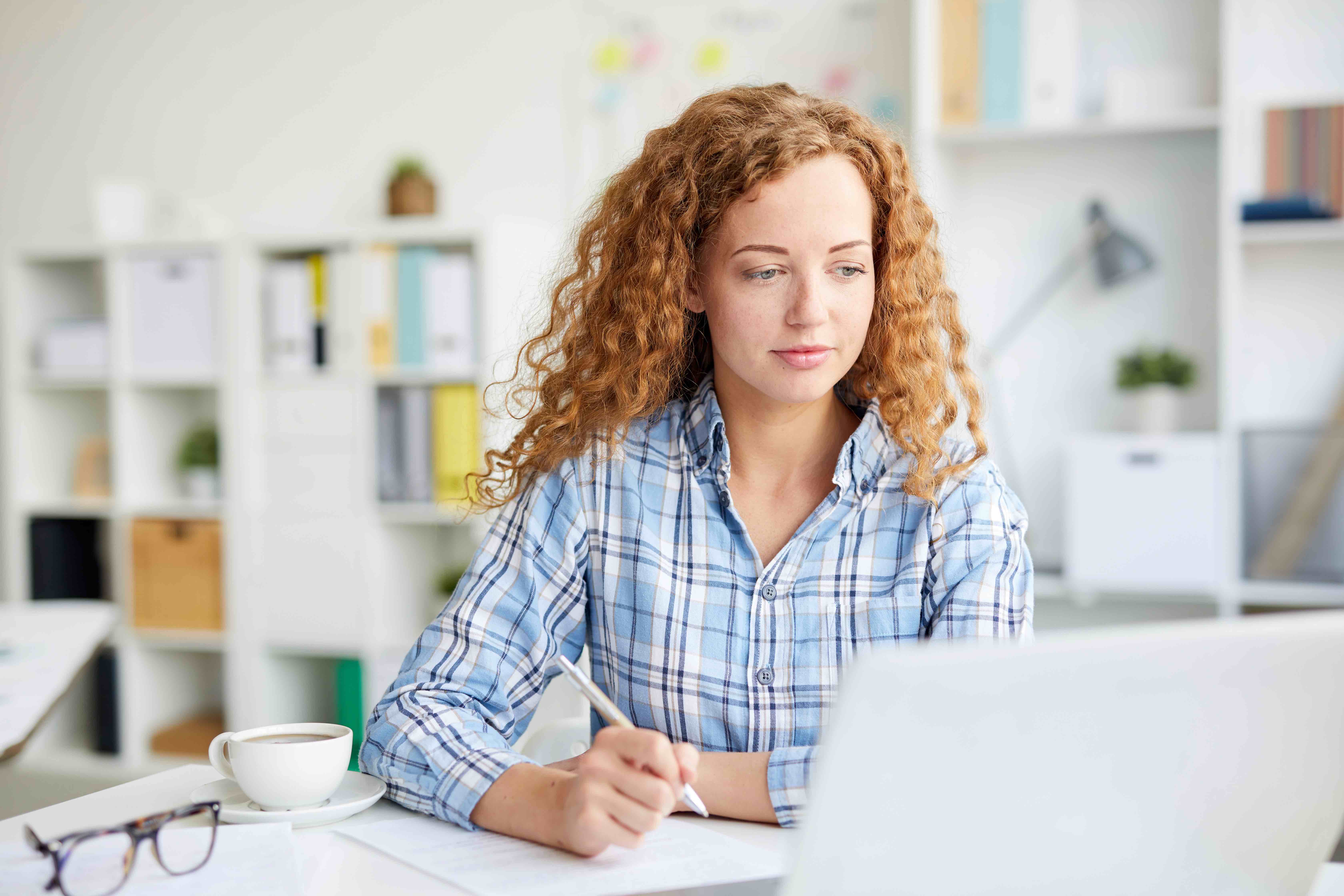 woman watching webinar on AI and taking notes